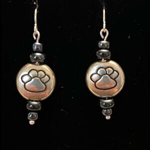 Handcrafted silver tone earrings with paw print and black beading.